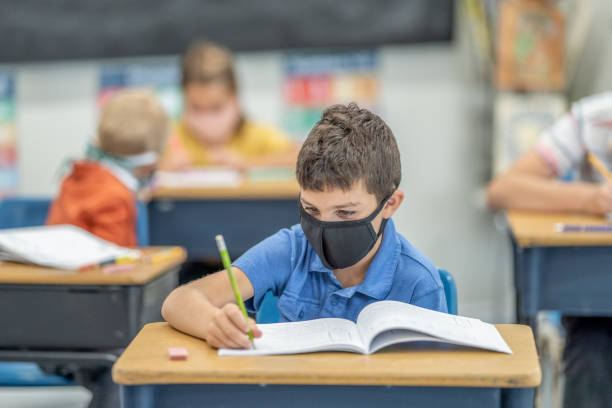 istock Young student wearing a protective face mask in the classroom 1263760321