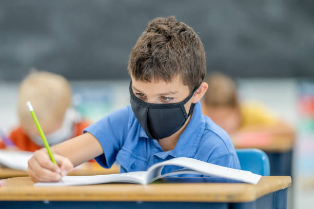 istock Young student wearing a protective face mask in the classroom 1263760322
