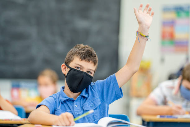 istock Young student wearing a protective face mask in the classroom 1263760330