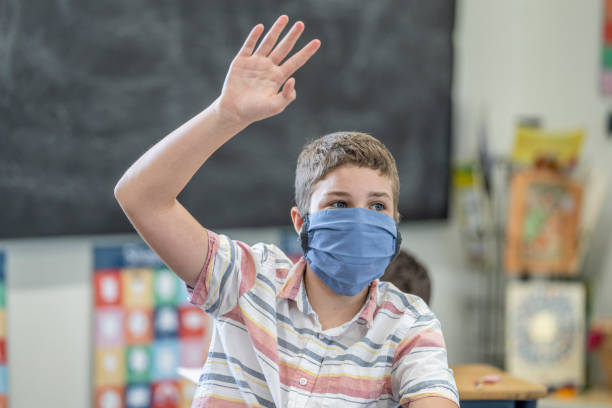 istock Young student wearing a protective face mask in the classroom 1263760341