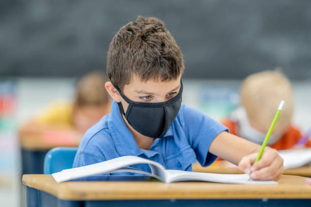 istock Young student wearing a protective face mask in the classroom 1263760349