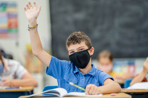 istock Young student wearing a protective face mask in the classroom 1263760354