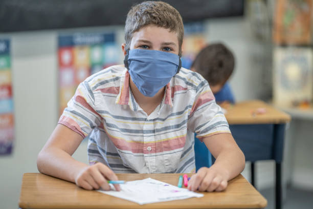 young student wearing a protective face mask in the classroom - sc0532 imagens e fotografias de stock