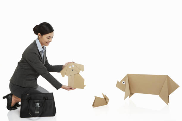 istock Businesswoman holding up a paper dog 1263762425