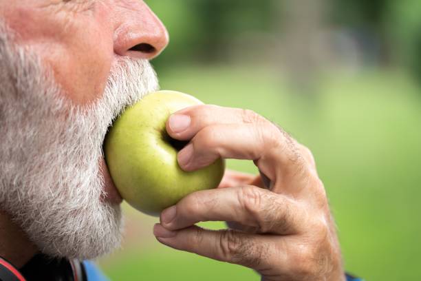 Senior sportsman eating green apple Senior sportsman eating green apple apple bite stock pictures, royalty-free photos & images