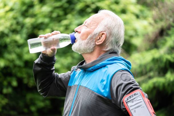istock Senior sportsman drinking water while exercising outdoors 1263770614