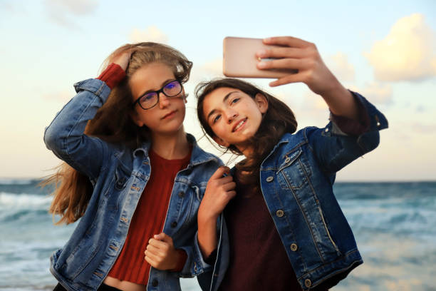 istock Young girls taking photos on the beach 1263771608