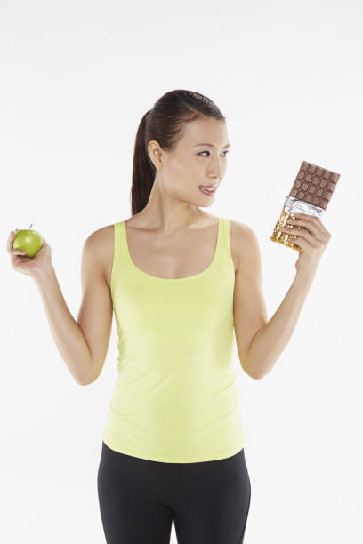 Measuring tape wrapped around a green apple as a symbol of diet.