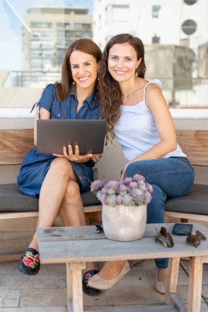 istock Portrait of female co-workers using laptop at hotel rooftop 1263774339