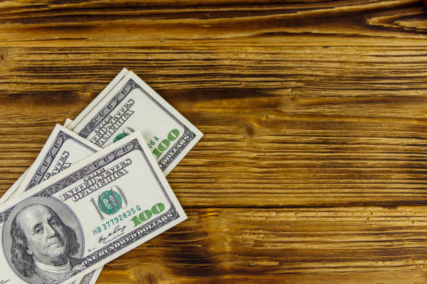 istock Stack of one hundred dollars bills on wooden desk 1263774366