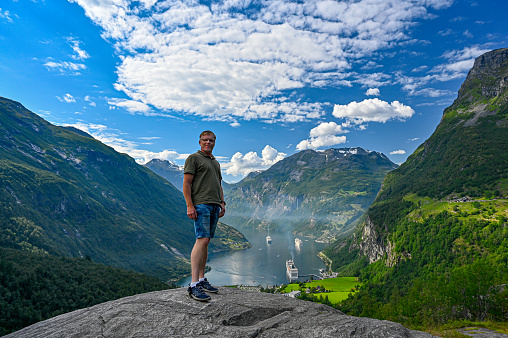 Male tourist standing high near Giranger in Norway with a scenic wiew
