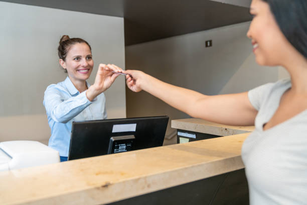 istock Female guest giving keycard back to receptionist for checkout 1263776119