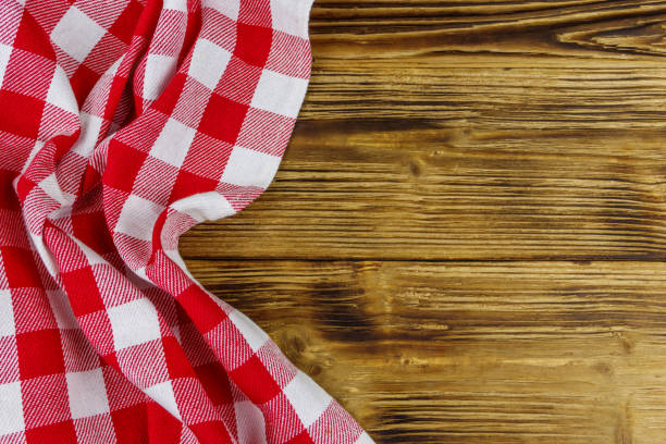 istock Red folded checkered napkin on rustic wooden kitchen table. Top view, copy space 1263777777