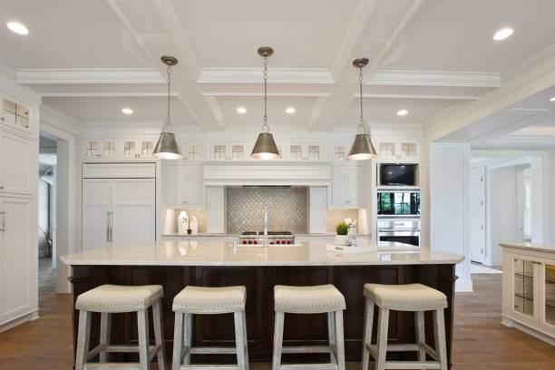 Spectacular kitchen in brand new tour home White kitchen with brown island and coffered ceiling home addition photos stock pictures, royalty-free photos & images