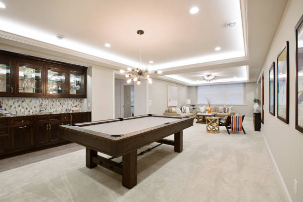Beautiful basement entertaining room with LED lighting in tray ceiling Billiards table with kitchenette nearby for everything you need in the basement basement stock pictures, royalty-free photos & images