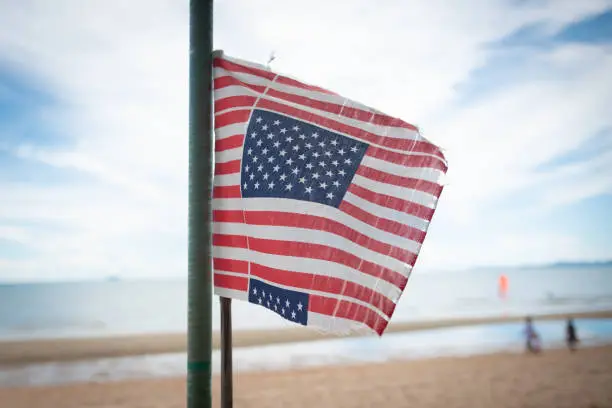 American Flag flying at the Beach,sea sand sky