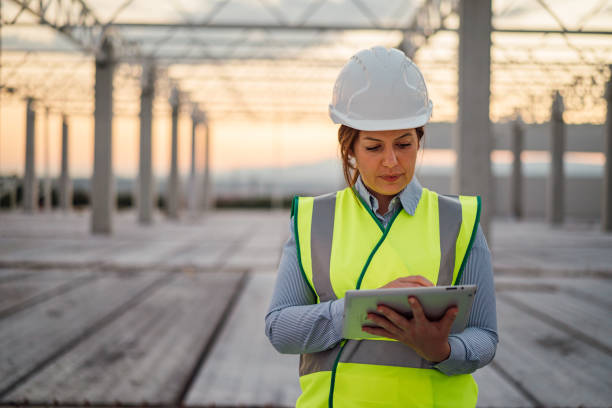 mujer ingeniera de construcción usando tableta - ingeniero de mantenimiento fotografías e imágenes de stock