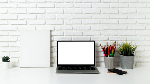 istock mockup laptop computer with blank white screen, with workspace and office supplies on a wooden desk 1263781261