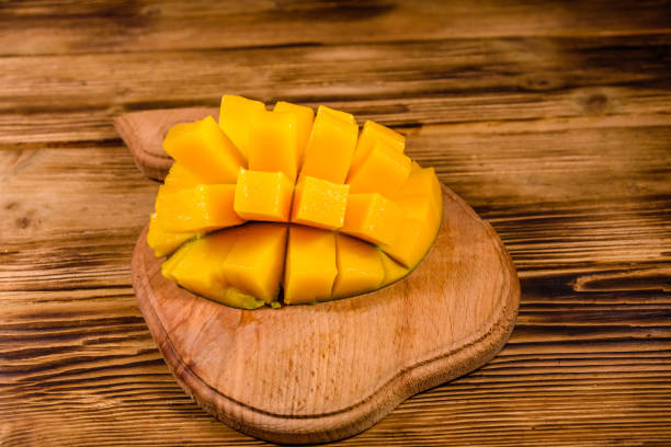 istock Cutting board with chopped mango fruit on a wooden table 1263785312