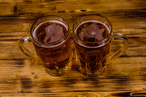 Two glasses of beer on rustic wooden table