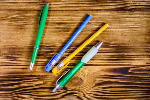 istock Multi colored ball pens on a wooden table. Top view 1263785343