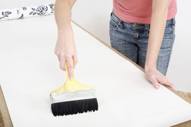 istock Woman applying glue on wallpaper 1263787202