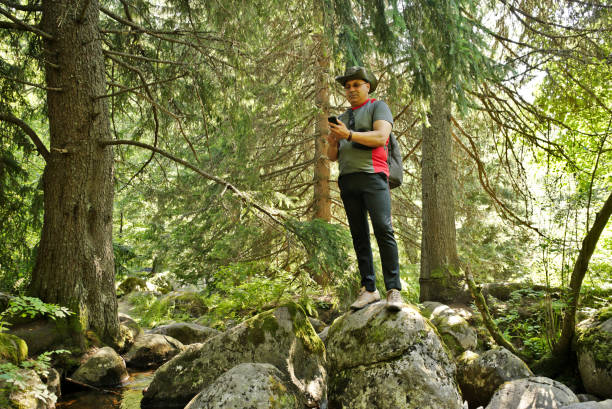 istock A Man With Smart-phone on Rocks in the Mountain 1263790692