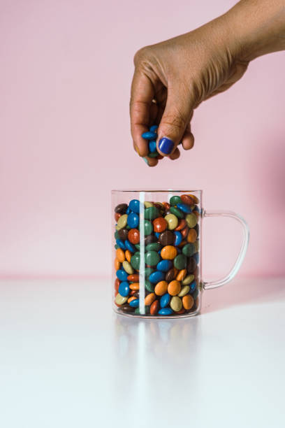 istock A hand holding candy colors from a cup 1263798466