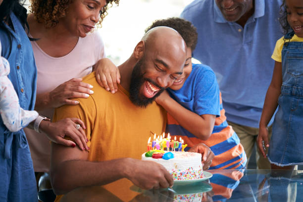 família afro-americana de várias gerações celebrando aniversário dos pais em casa juntos - grandmother grandson baby mother - fotografias e filmes do acervo