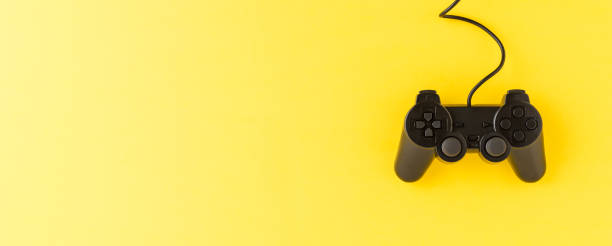 istock Black video game console on yellow background with copyspace. Top view. Banner 1263801738