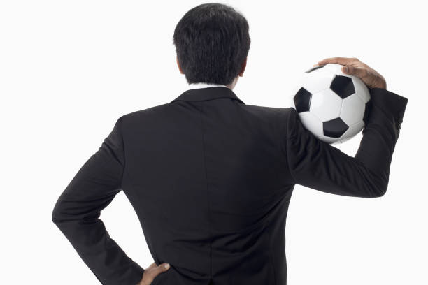 gestionnaire de football retenant un ballon - football coach business ball photos et images de collection