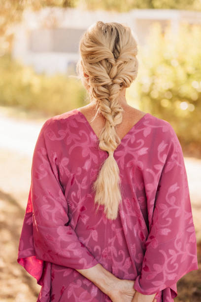 Blond long hair in braid hairstyle outdoors in sun in summer\nWoman with braided hair