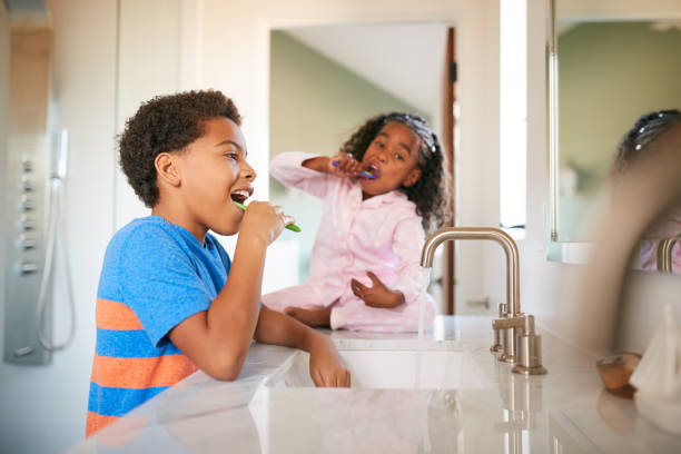 istock Two Children Brushing Their Teeth In Bathroom At Home 1263804047