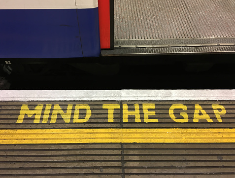 London, UK - 12 19 2017: Mind the Gap warning sign on a underground platform at a London Underground Station