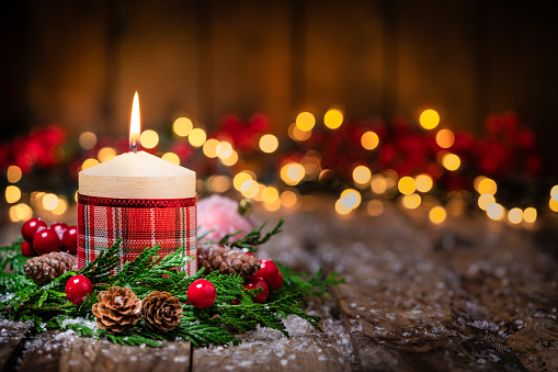 Advent wreath with red burning candles and Christmas decoration against a dark blue background with bokeh lights and stars, panoramic format, copy space, selected focus, narrow depth of field