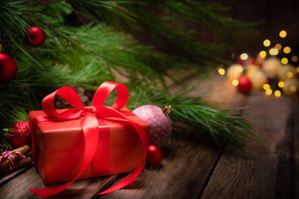 istock Red Christmas present with ornaments on rustic wooden table. Copy space 1263824735