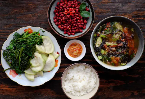 Top view Vietnamese vegan food for daily meal, boiled gourd, water spinach with tofu cheese, fried peanut with soy sauce and seaweed soup, simple dish for lunch time in non meat diet, good for health