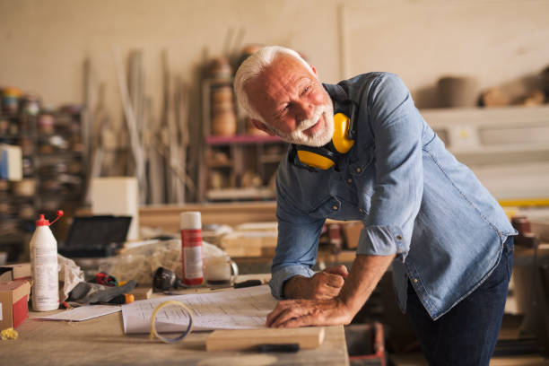 istock Nice elderly craftsman looking behind his back and smiling 1263826038