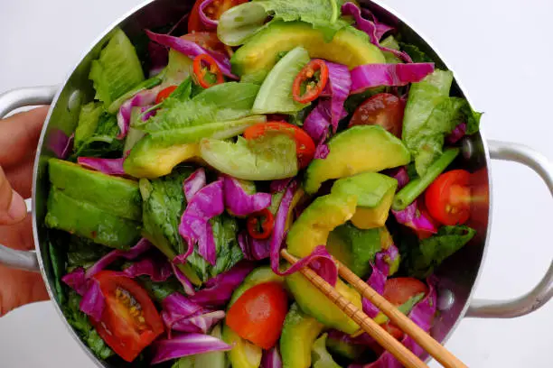 Top view Vietnamese vegetarian cuisine, mixed vegetable from avocado, salad, tomato, violet cabbage with soy sauce, lemon, chili, delicious homemade diet food for weight loss and nutrition vegan dish