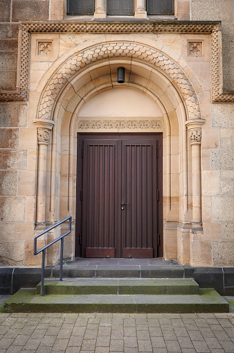 High-res photograph of a brown wooden church door.