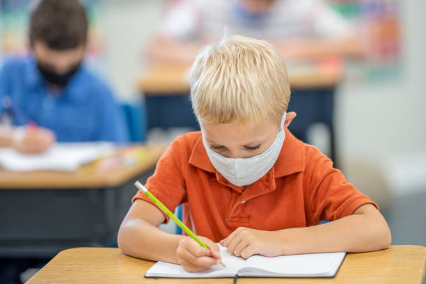 istock Young student wearing a protective face mask in the classroom 1263831465