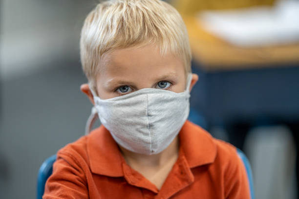 istock Young boy sitting in class wearing a face mask 1263831467