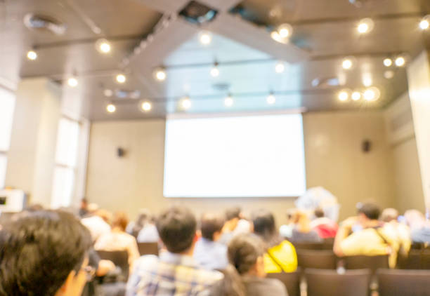 istock Blur background seminar business event in auditorium  hall convention audience presentation meeting at conference room present screen for entrepreneurs startup business. Blurred background copy space 1263837232