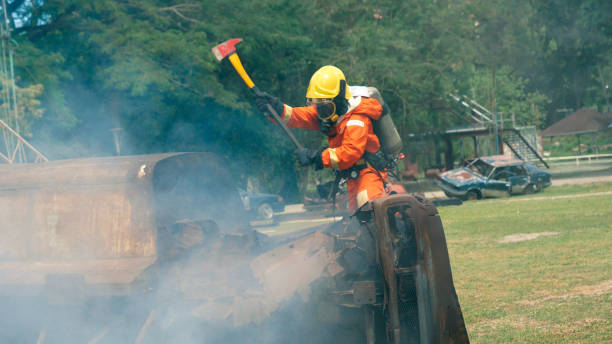 istock Firefighter fighting with flame using fire hose chemical water foam spray engine. Fireman wear hard hat, body safe suit uniform for protection. Rescue training in fire fighting extinguisher 1263837253