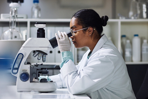 Cropped shot of an attractive young female scientist working on a microscope in her laboratory
