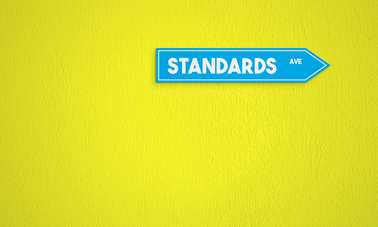 Standards Directional Sign On The Yellow Wall Background. Horizontal composition with copy space.