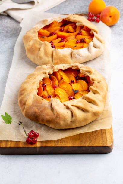 istock Fruit galette on light background. Homemade open pie with apricots and red currant. 1263841070