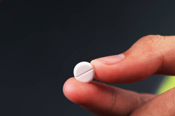 istock White pill in the finger grip 1263841508