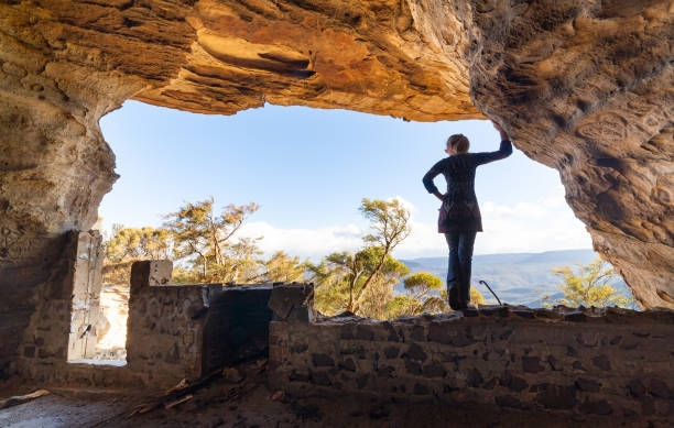 istock Woman standing in cave looking out to valley views 1263842449