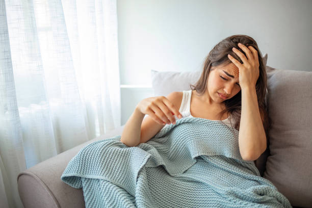 istock Sick woman lying in bed with high fever. 1263846329